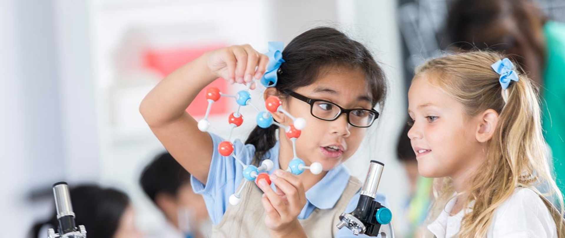 Two primary school children looking at the structure of an atom.