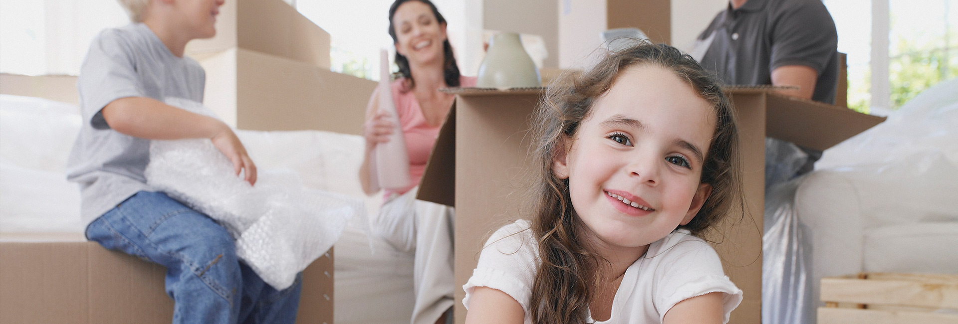 Header image showing family happily unpacking boxes in their new home