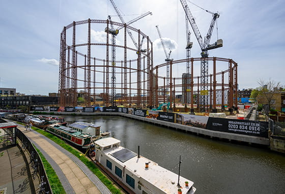 An exterior photograph of some gasholder frames with construction work around