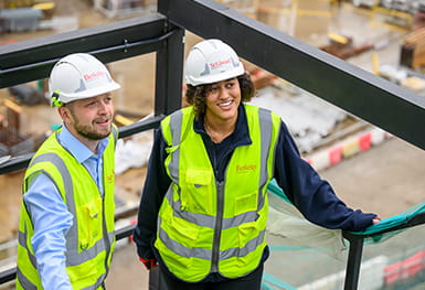 An image of two people standing on a construction site