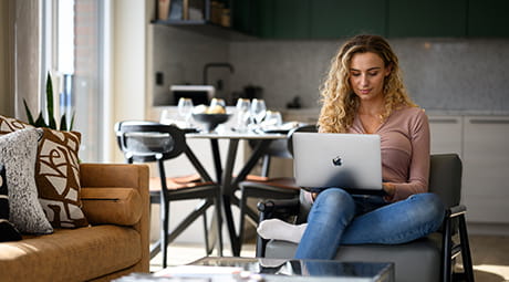 An image of a woman sat working on her PC in the Living / Dining / Kitchen area