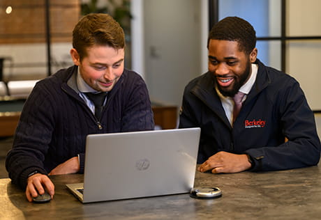 An image of 2 people looking at a laptop screen together