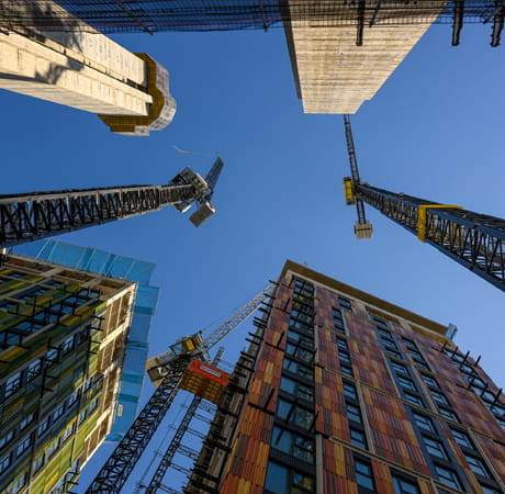 An image looking up at tall buildings under construction