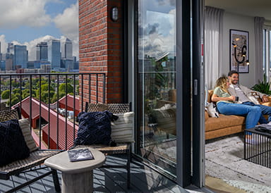 An image looking in from the balcony at a couple on the sofa