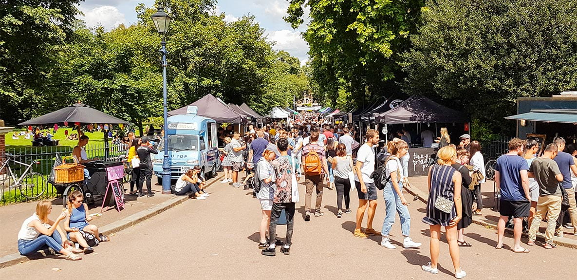 A group of people walking in Victoria Park in East London.