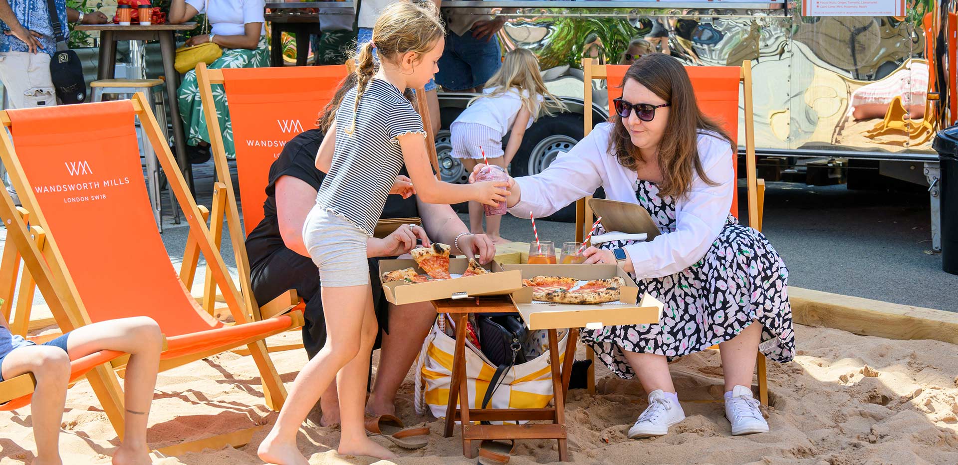 An image of a family sat eating some food at The Beach Club