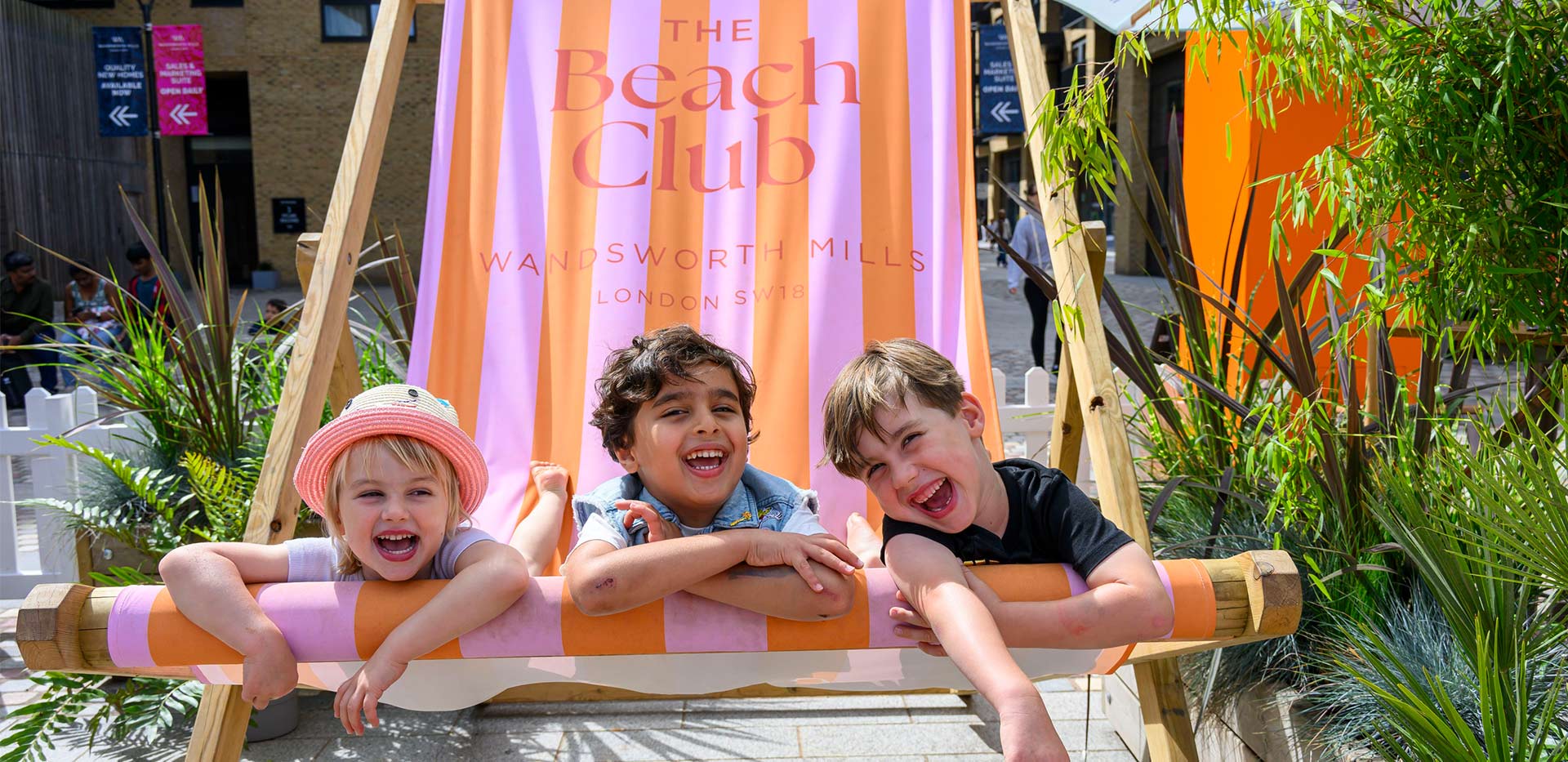 An image of children sitting on the giant chair at The Beach Club
