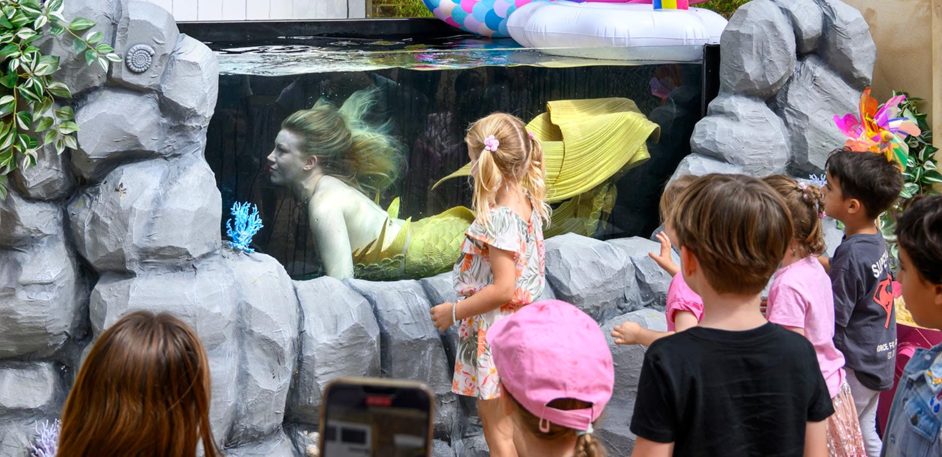 An image of children watching a mermaid at The Beach Club