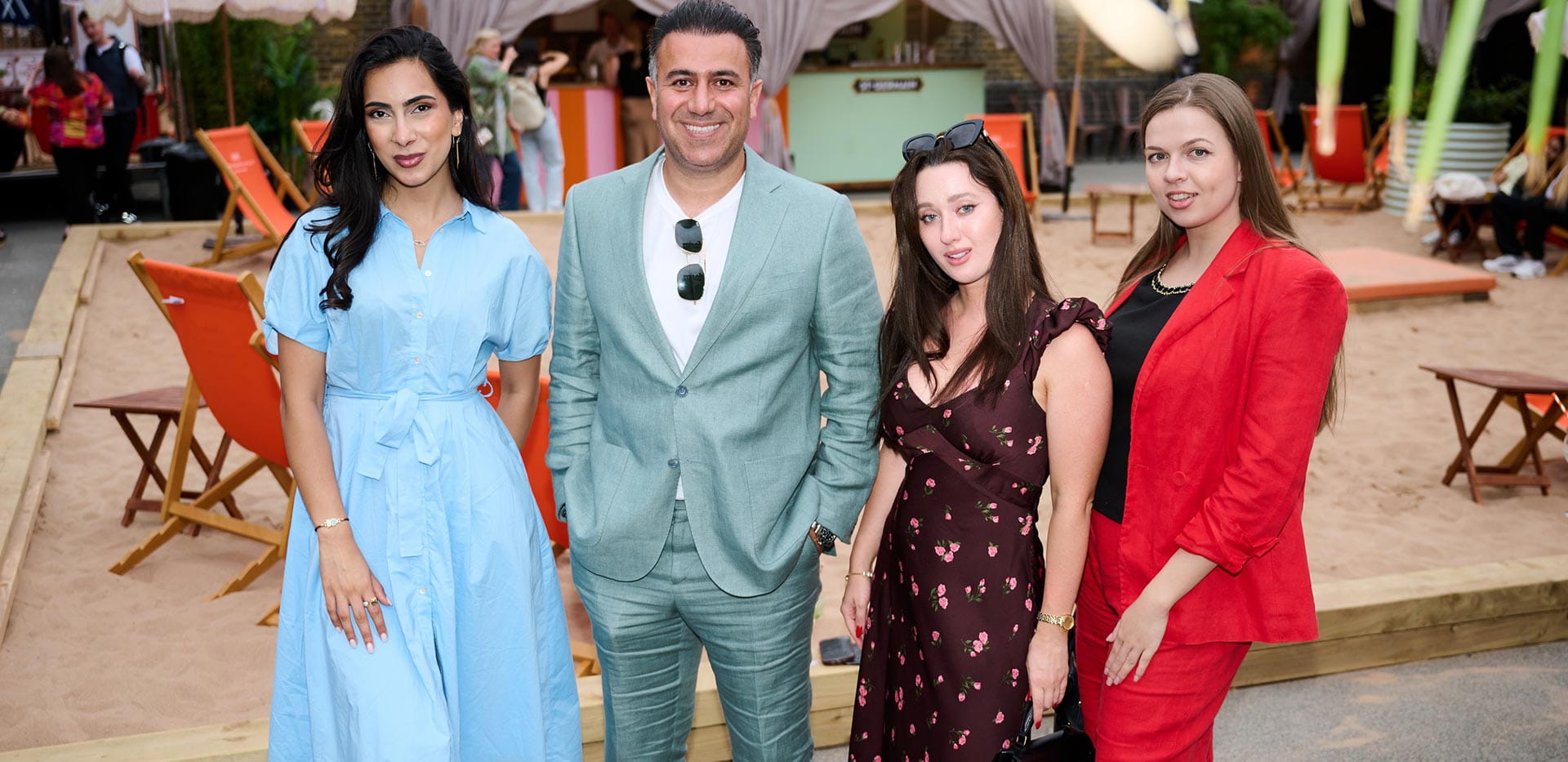 An image of people standing in front of the sand at The Beach Club