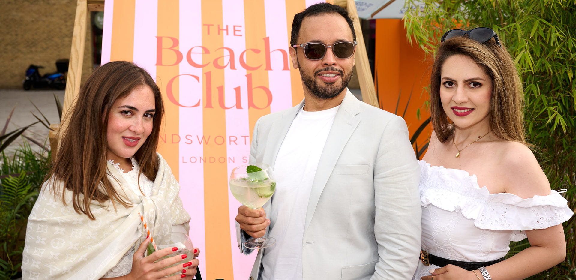 An image of people standing in front of the giant chair at The Beach Club