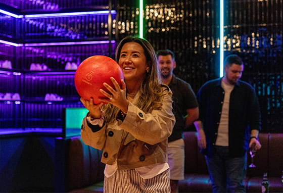 An image of a woman bowling at the Grand Union bowling alley