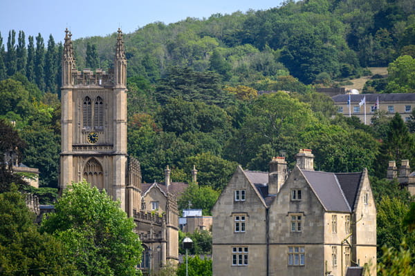 Grand and tall church set amongst green vegetation with hilly backdrop