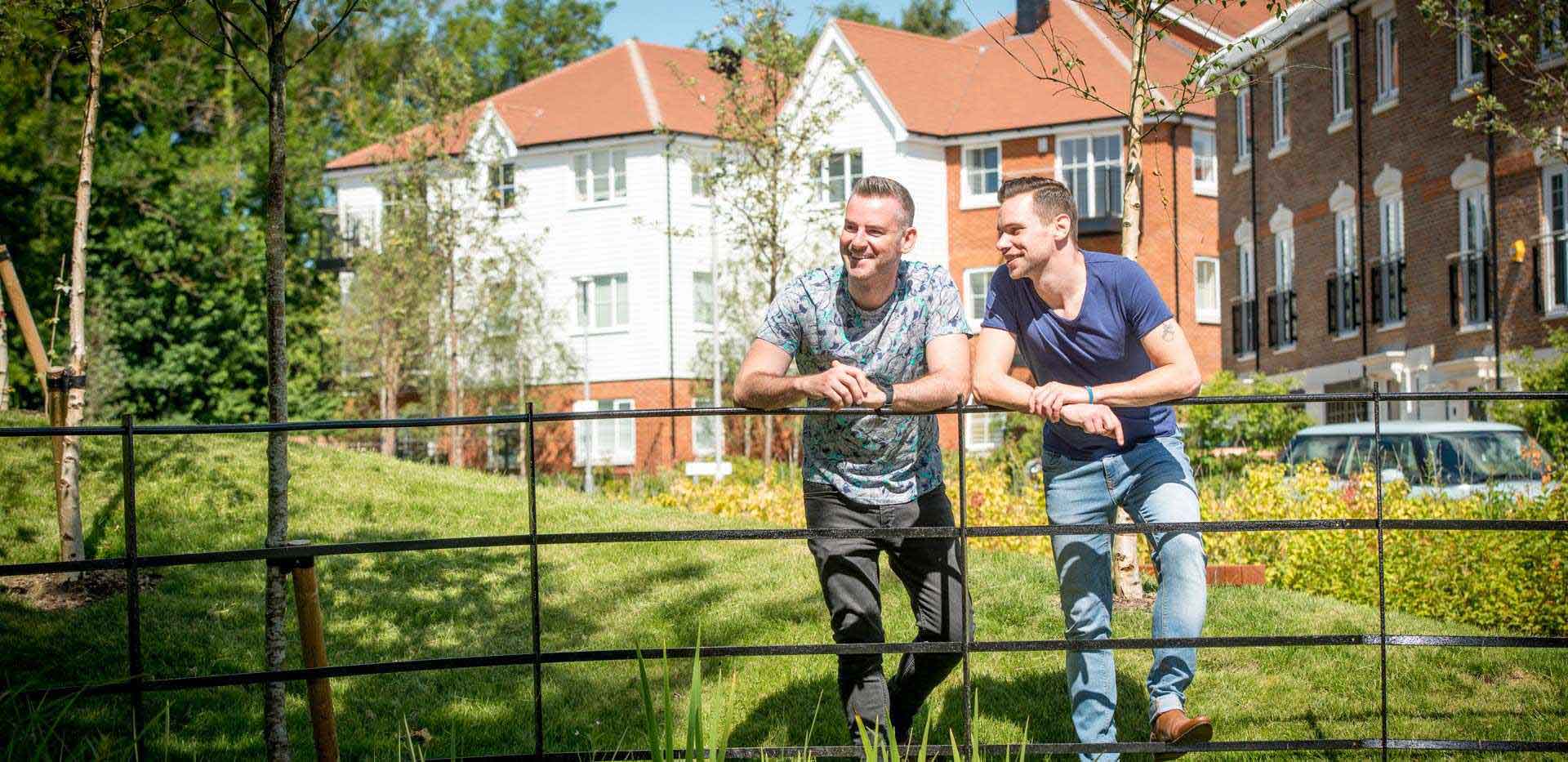 Berkeley Group homeowners, Frank and Paul, stood in a green space with new build houses in the background.