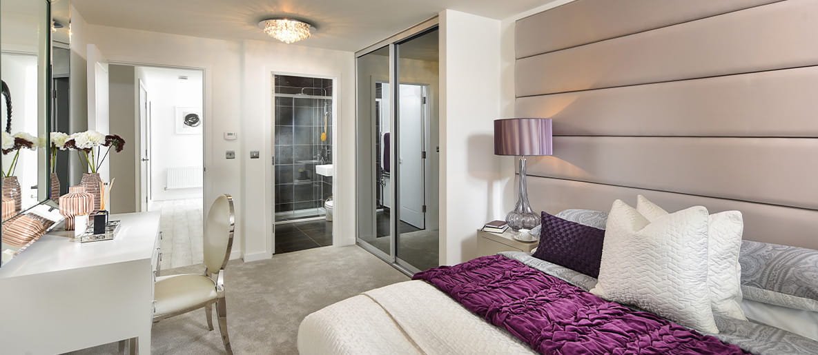 An example bedroom of a new build apartment at Ryewood development, featuring modern décor, a fitted wardrobe and an en-suite.