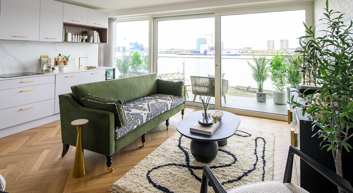 The living area and balcony of an apartment, featuring outdoor seating to relax.