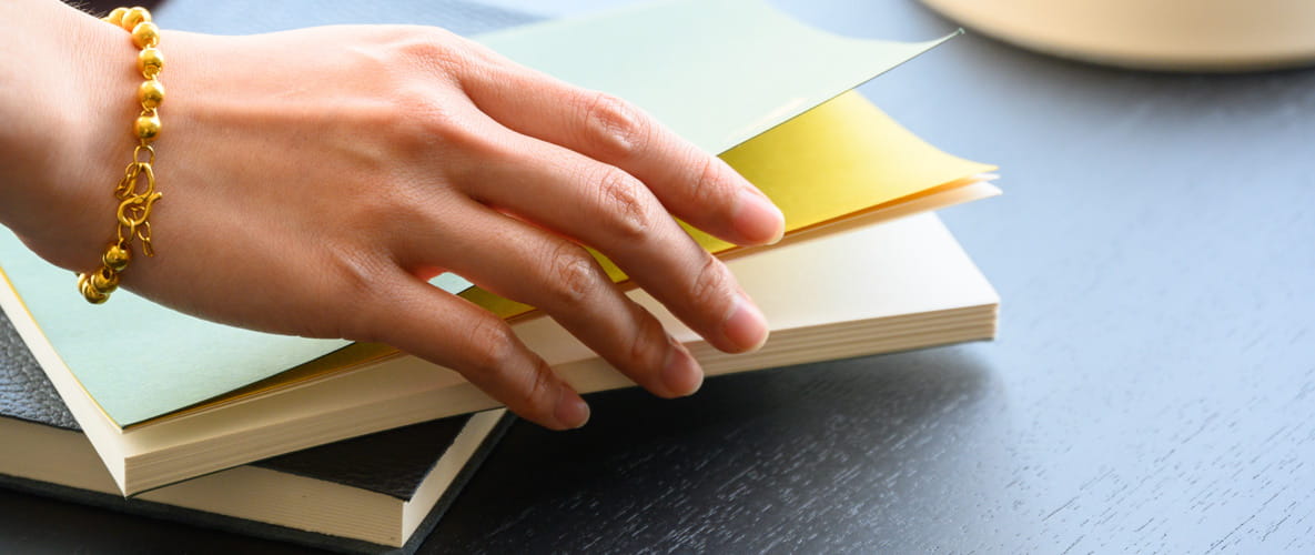 Fist time buyer paperwork with a woman's hand picking up paper