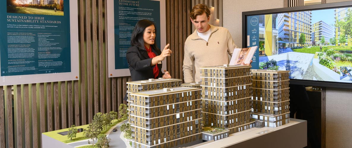 Sales agent showing home buyer a new build development model