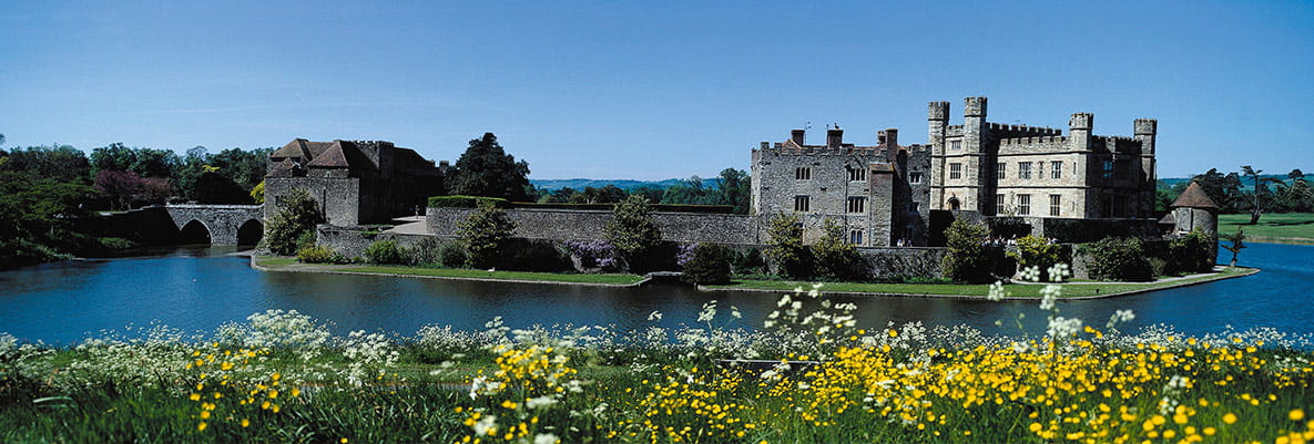 Two locals sit in camping chairs and admire the view of Tonbridge Castle in Kent. 