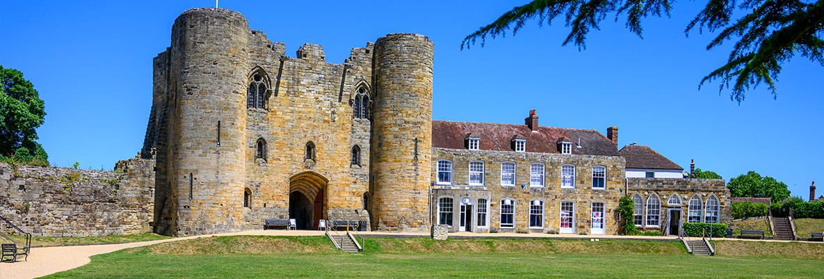Two locals sit in camping chairs and admire the view of Tonbridge Castle in Kent.