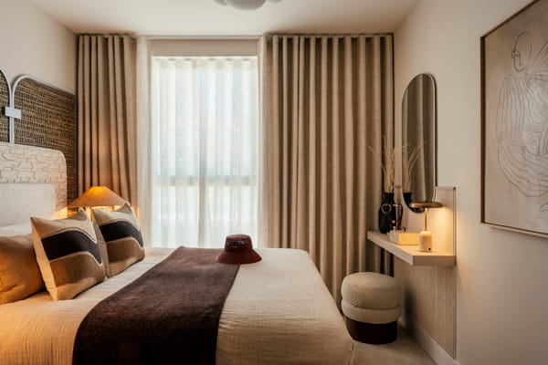 Modern designed bedroom with floor to ceiling curtains, light brown-beige colour palette