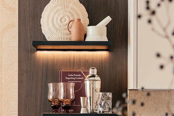 Bespoke shelf units with strip lighting against a wooden textured wall panel