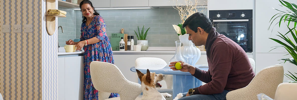 An image of the couple in the apartment playing with their dog