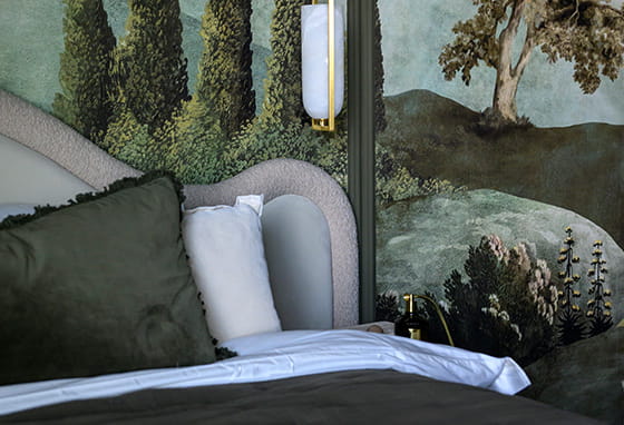 A close up image of a bed and pillows and feature wall