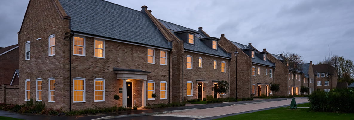 A row of new build houses with newly constructed pavement and landscaping in front