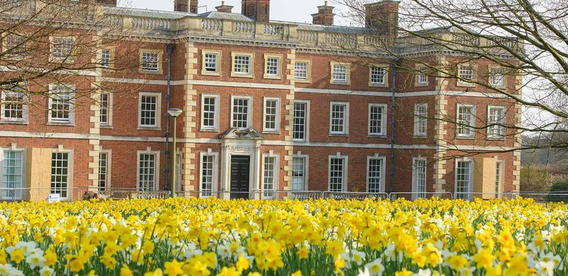 The exterior of the mansion house at Trent Park, features red bricks and white windows which overlook the famous Daffodil Lawn.