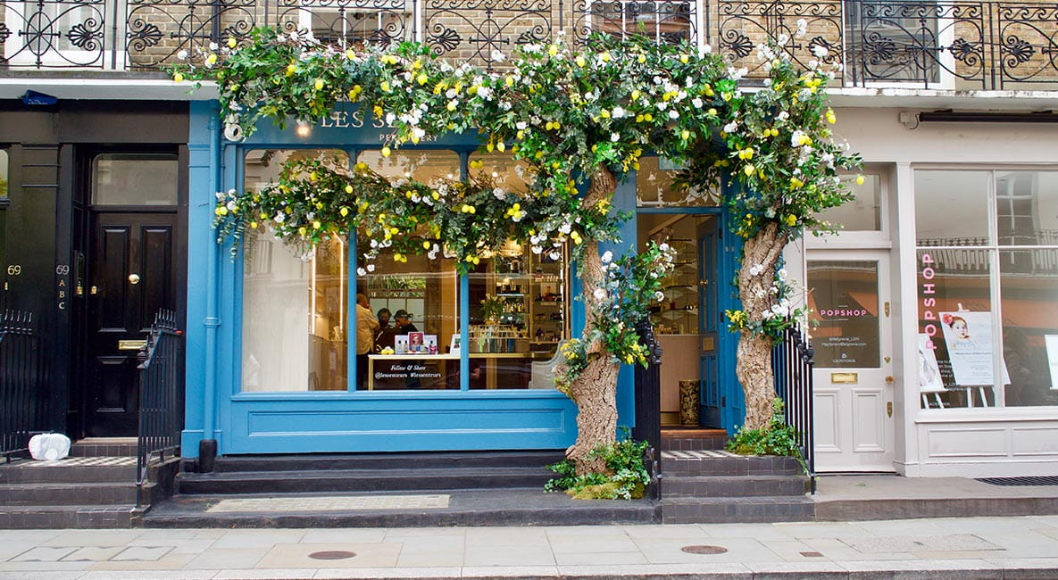 Exterior of shop with blue paint and covered in flowers
