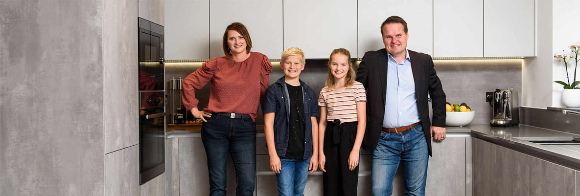 Married couple, Rasmusand and Rikke, stand on either side of their two children in their new home, following their move to Horsham from Scandinavia.