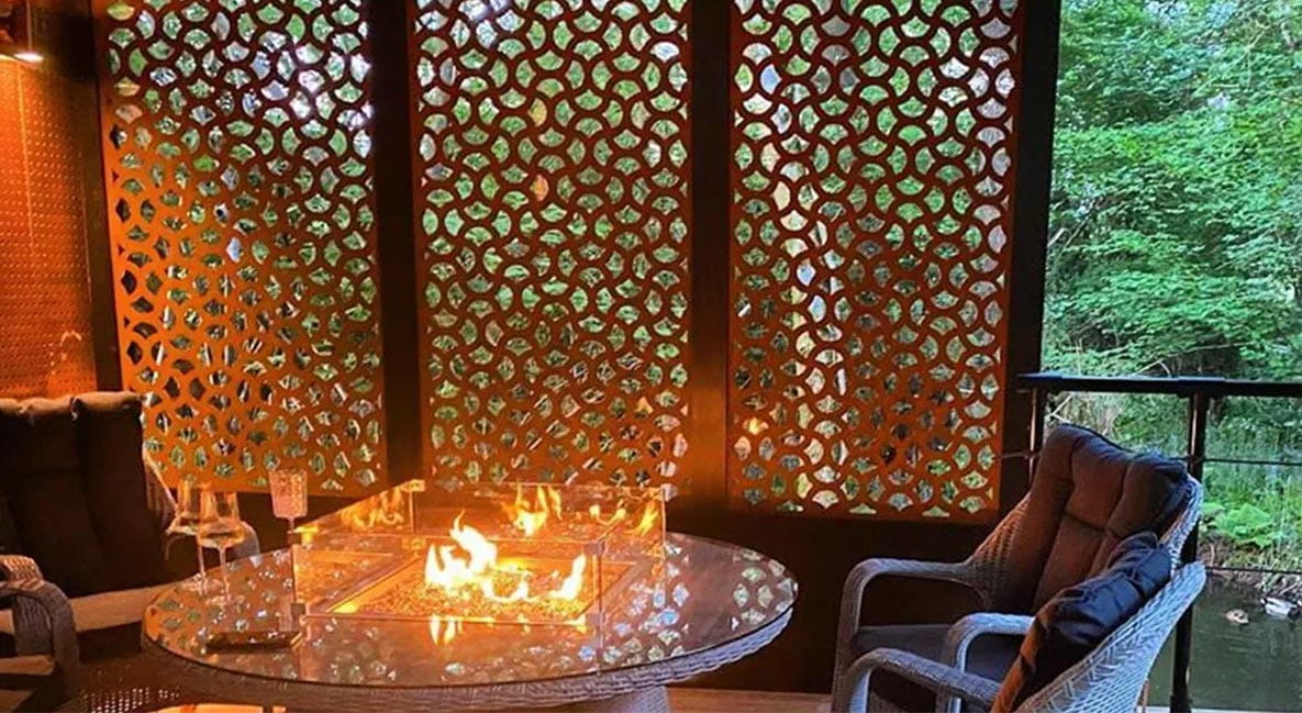 A cosy outdoor seating area with latticework panels and candles on the table.