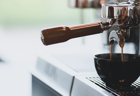 A mug is filled with coffee under a bean-to-cup dispenser in a Battersea coffee shop. 
