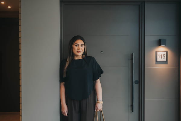 Faiza posing against new build flat door entrance.