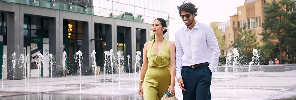 An image of a couple walking past a water feature at London Dock