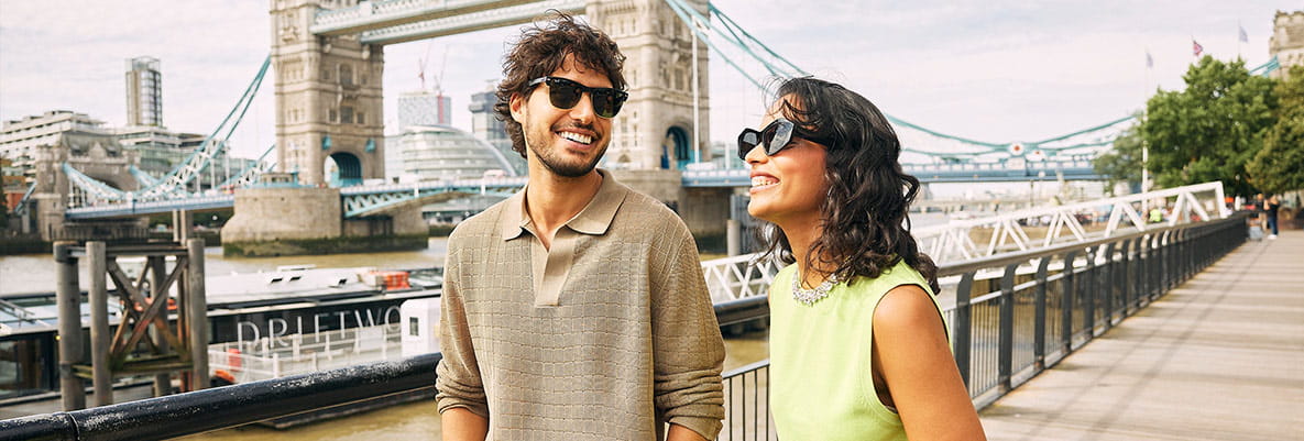 An image of a couple walking along the Thames in London