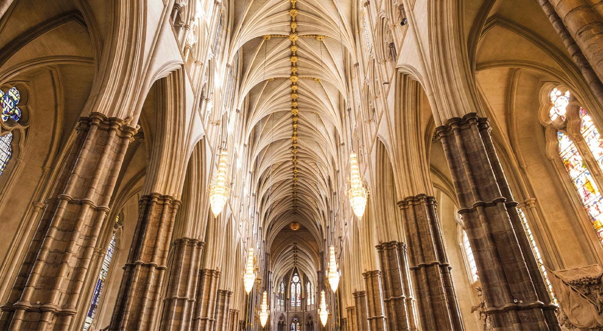 The interior of Westminster Abbey. The building features traditional architecture with large ceilings and stained glass windows.