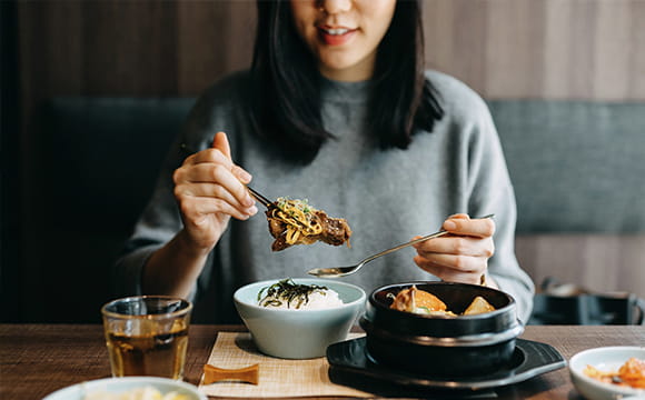 Image of woman eating Chinese meal at restaurant