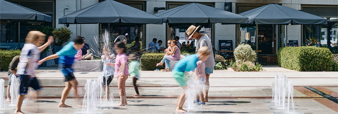 Children plating near the water feature outside London Dock