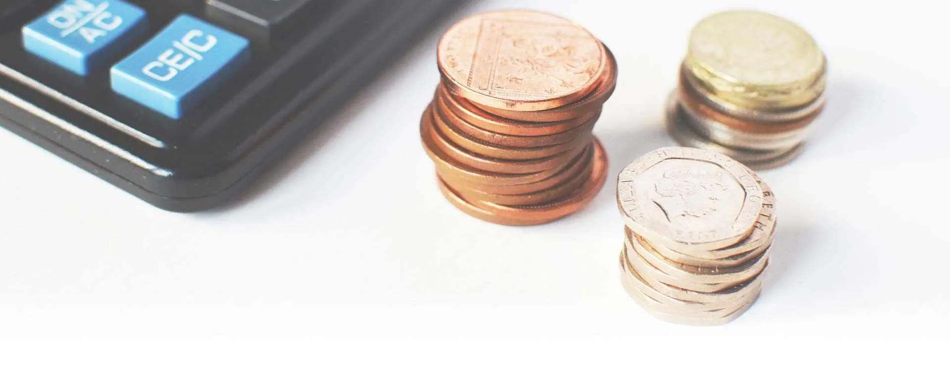 Three stacks of coins next to a calculator