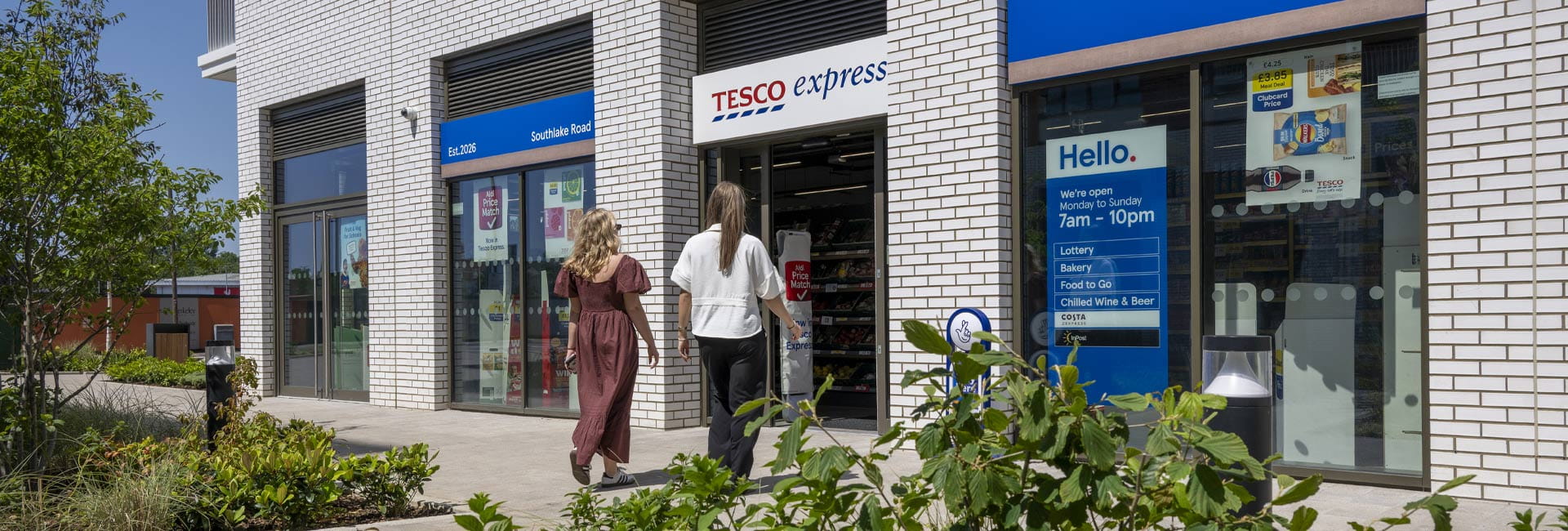 Image of people walking into s Tesco express