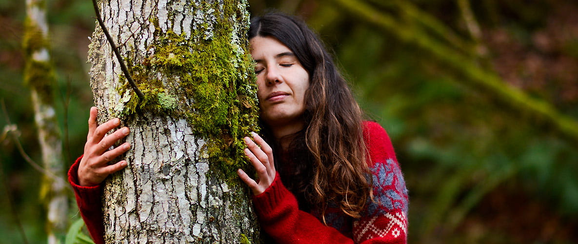 An image of a woman hugging a tree