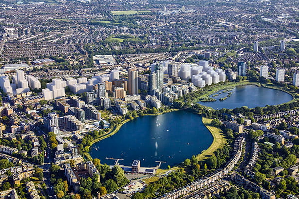 Oblique aerial view of Woodberry Down development amongst greenery and water bodies.