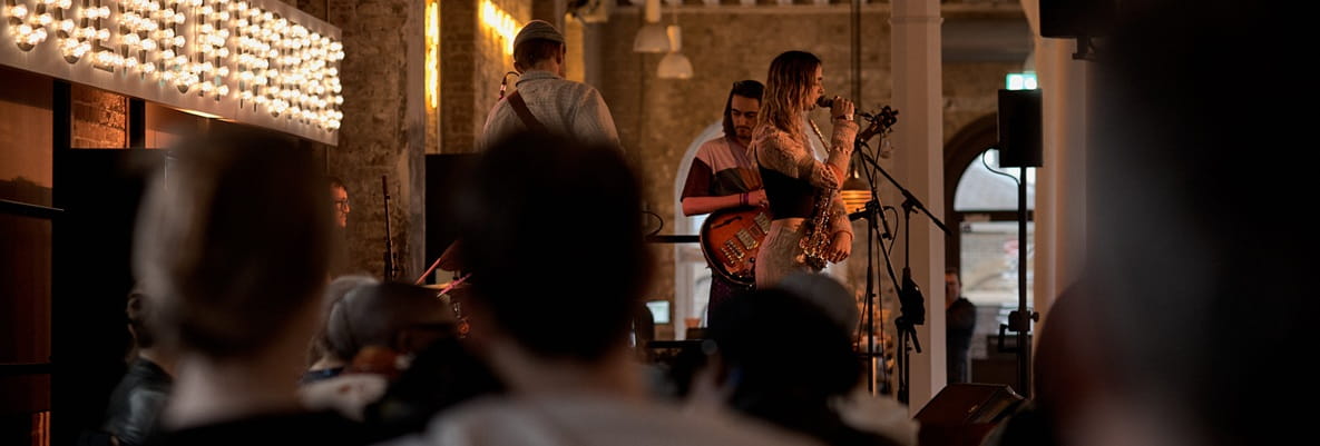 A band on stage performing live at an indoor venue.