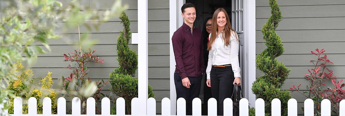 An image of a couple in the doorway to their new home