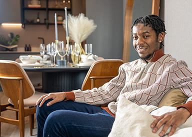 An image of a person sat on a chair in their new home