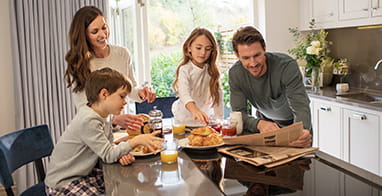 An image of a family in their kitchen eating together