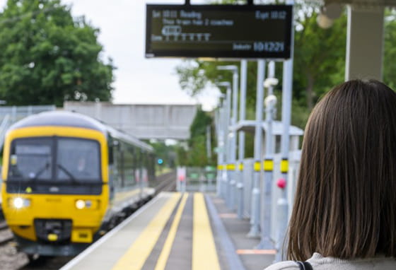 A woman standing on a platform at a train station in Reading