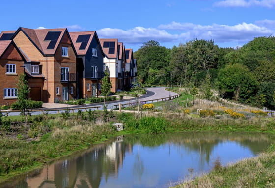New build houses in front of a pond at Abbey Barn Park