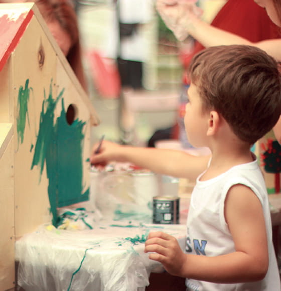 A child painting a birdhouse at a nursery in Fleet